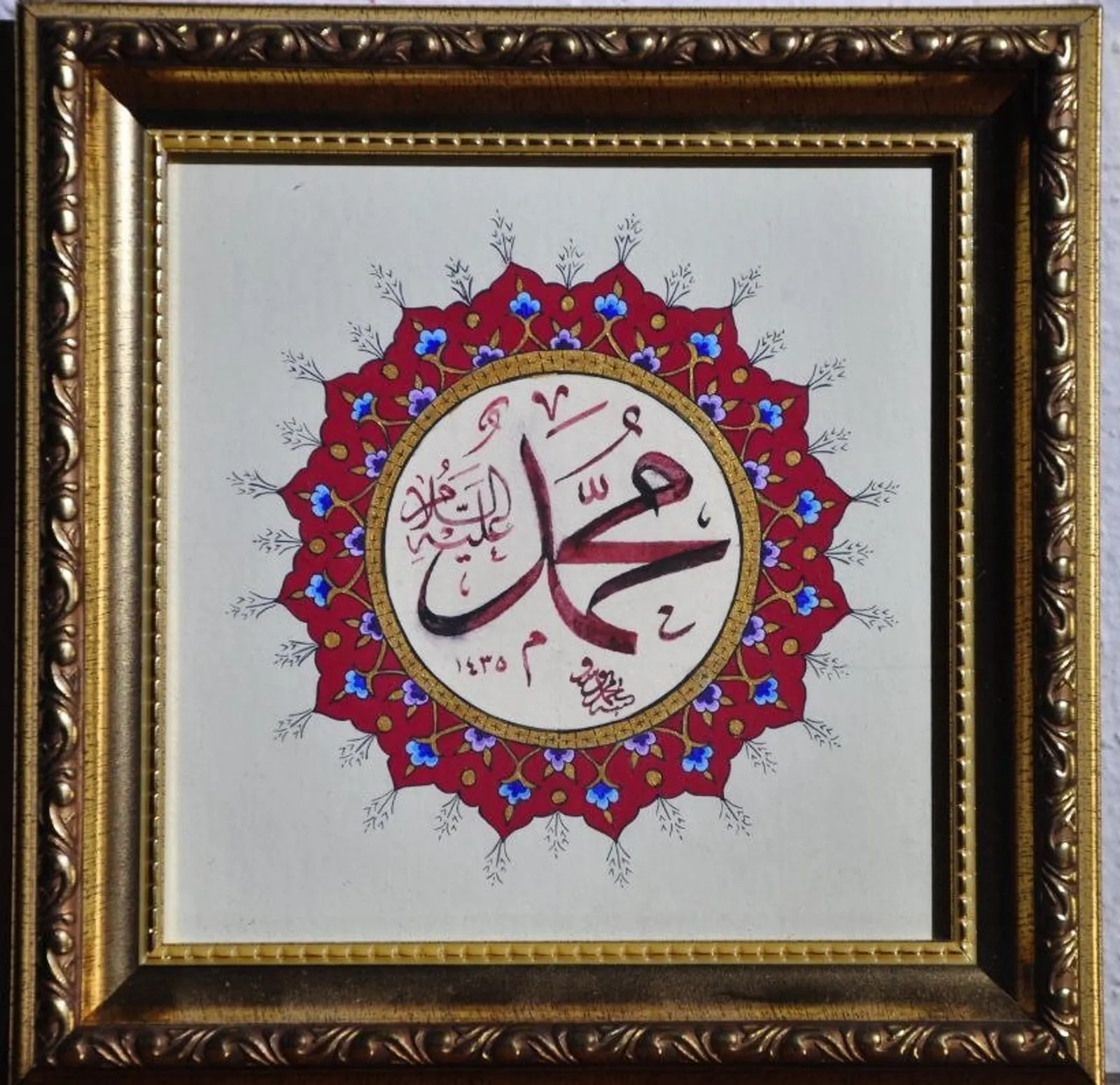 Kırmızı ve altın tezhipli madalyon içinde Muhammed aleyhisselâm yazısı